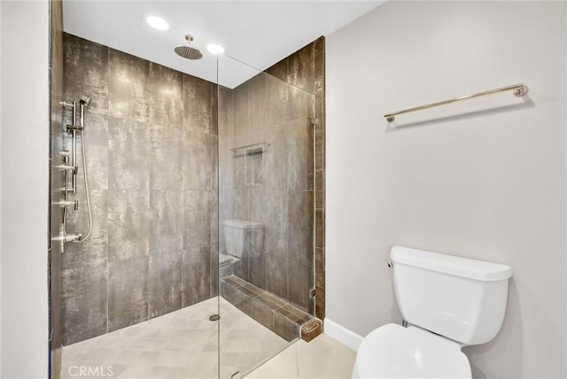 bathroom featuring tile patterned flooring, toilet, and a shower with door