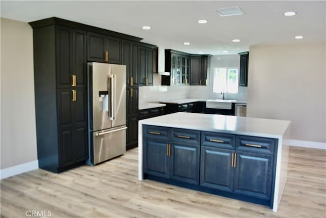 kitchen with a center island, stainless steel appliances, light hardwood / wood-style flooring, and sink