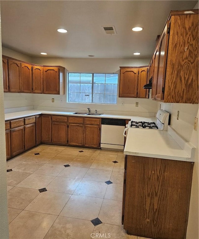 kitchen featuring light tile patterned flooring, white appliances, and sink