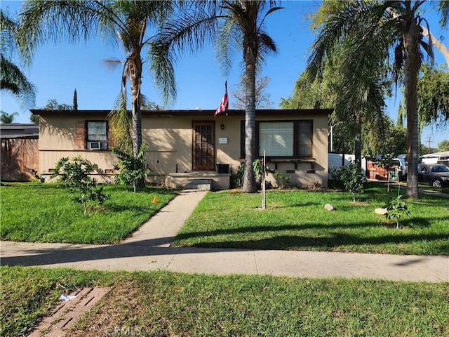 ranch-style home with cooling unit and a front lawn