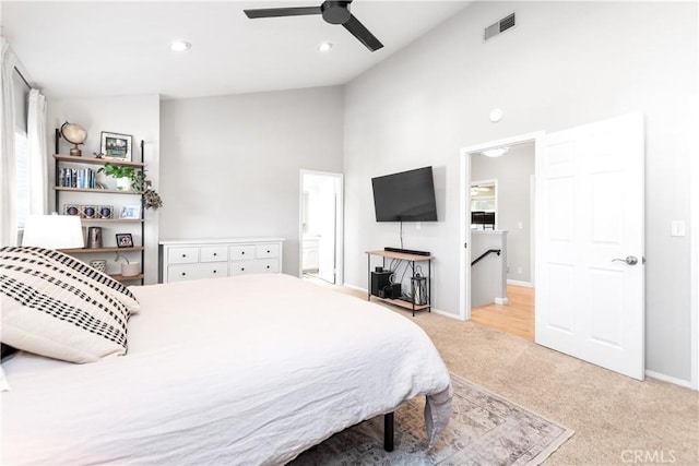 bedroom featuring connected bathroom, light colored carpet, high vaulted ceiling, and ceiling fan