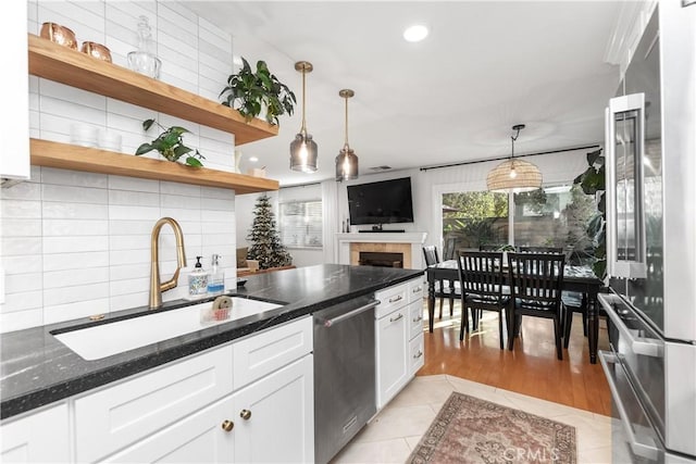 kitchen featuring decorative backsplash, white cabinetry, sink, and stainless steel appliances