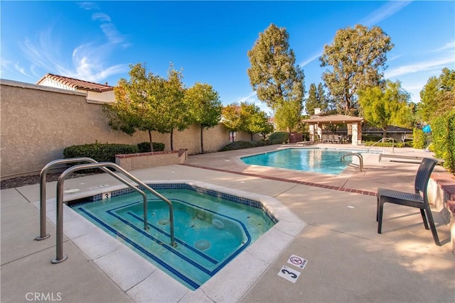 view of pool featuring a patio and a hot tub