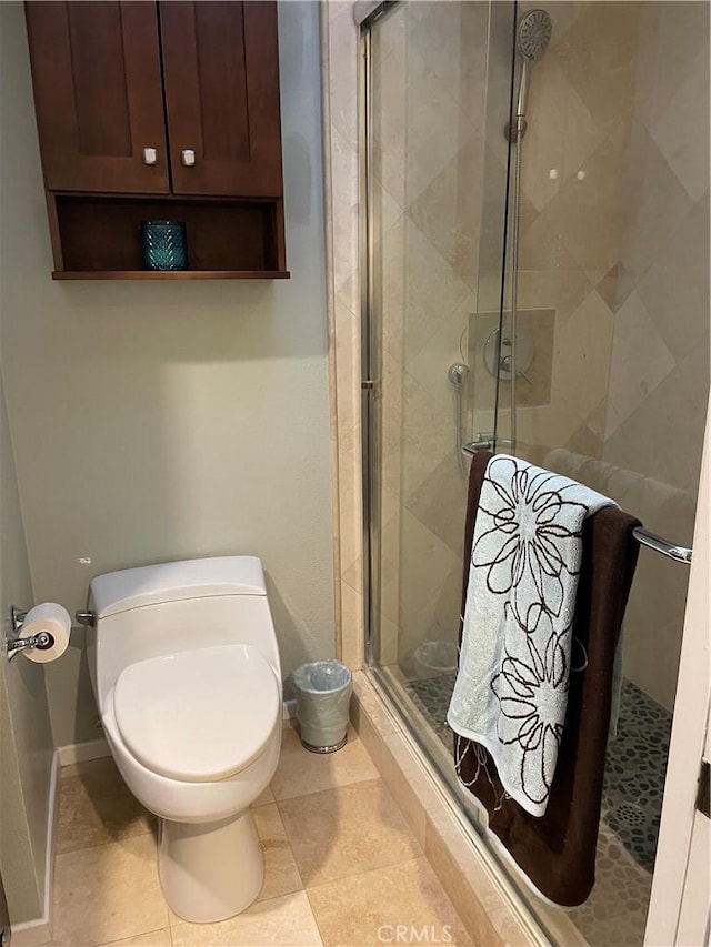 bathroom with toilet, tile patterned flooring, and walk in shower