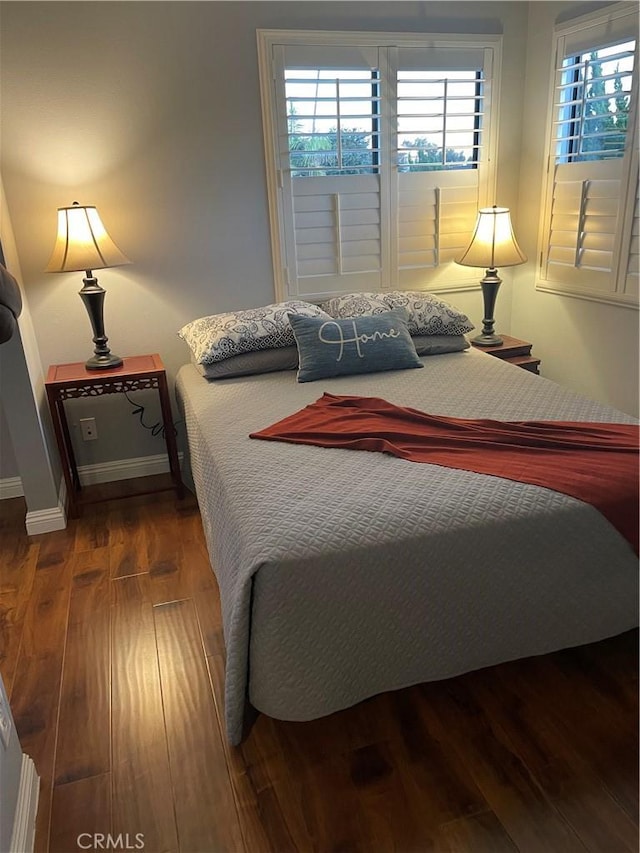 bedroom with dark hardwood / wood-style floors