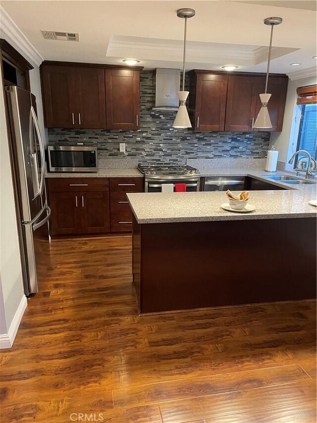 kitchen featuring dark hardwood / wood-style flooring, sink, stainless steel appliances, and hanging light fixtures