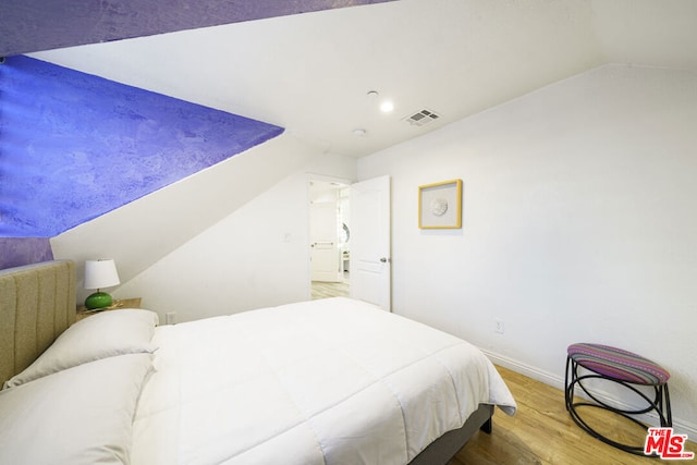 bedroom featuring hardwood / wood-style floors and lofted ceiling