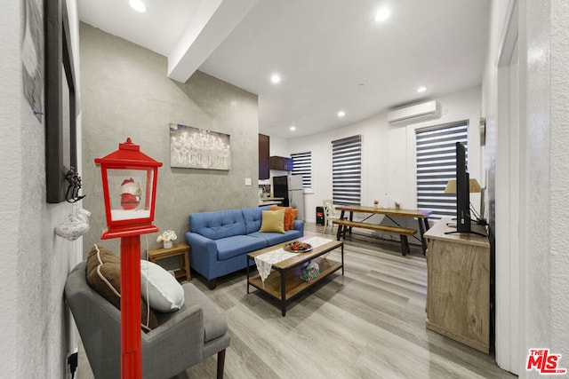 living room featuring a wall mounted air conditioner and light hardwood / wood-style flooring