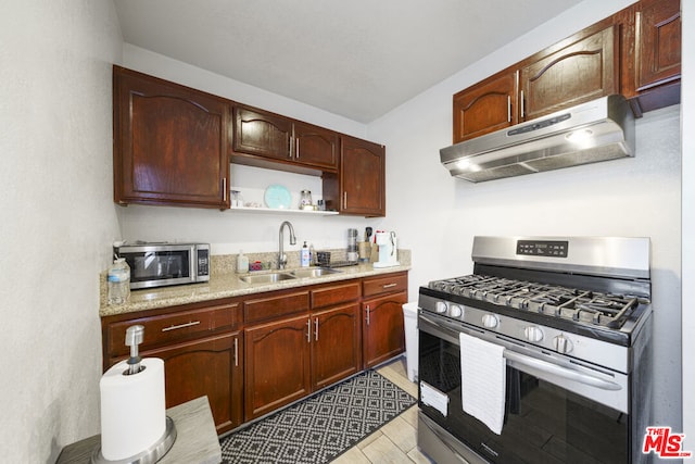 kitchen with sink, light stone countertops, and stainless steel appliances