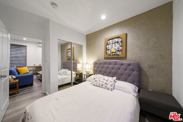 bedroom with hardwood / wood-style flooring and a closet