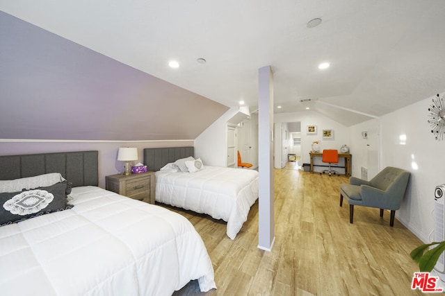 bedroom with light hardwood / wood-style floors and lofted ceiling