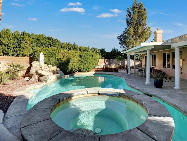 view of pool with a patio area and an in ground hot tub