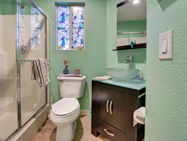 bathroom featuring vanity, toilet, an enclosed shower, and tile patterned flooring