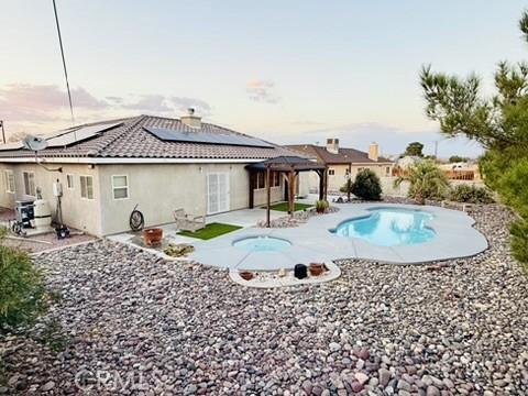 pool at dusk featuring a patio