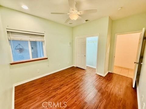 unfurnished bedroom with hardwood / wood-style floors, ceiling fan, and a closet