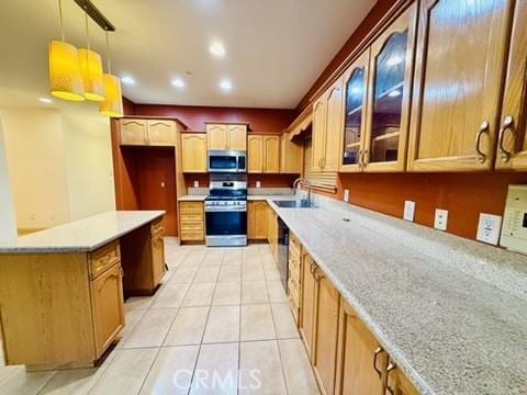 kitchen with sink, stainless steel appliances, light stone counters, decorative light fixtures, and light tile patterned flooring