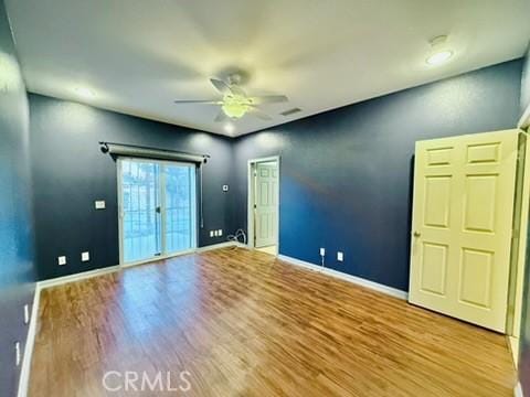 empty room with ceiling fan and light hardwood / wood-style floors