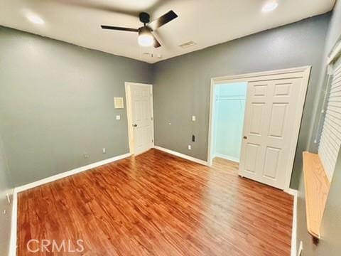 unfurnished bedroom featuring hardwood / wood-style flooring, ceiling fan, and a closet