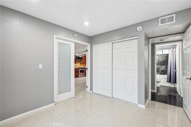 unfurnished bedroom featuring a closet and light tile patterned flooring