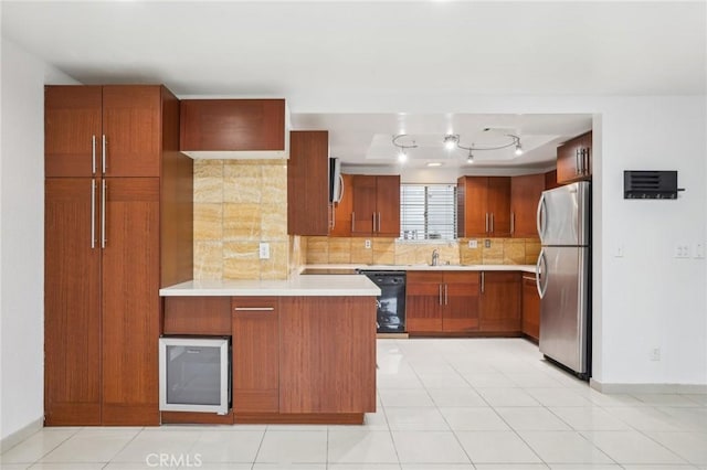 kitchen featuring sink, black dishwasher, backsplash, stainless steel fridge, and light tile patterned floors