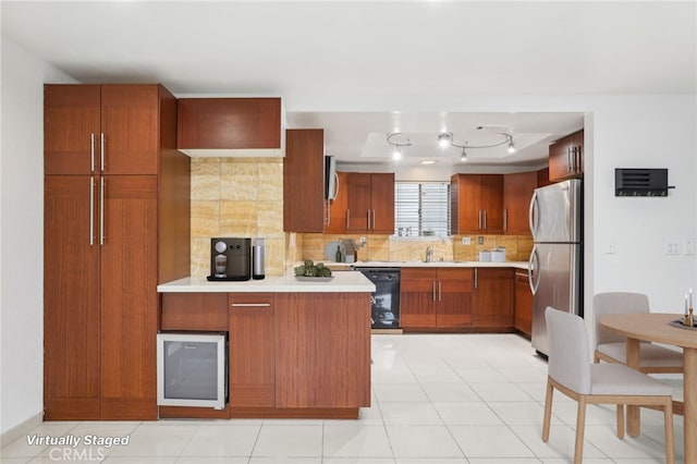 kitchen with backsplash, sink, black dishwasher, light tile patterned flooring, and stainless steel refrigerator