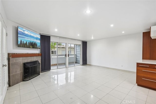 unfurnished living room with a fireplace, light tile patterned floors, and french doors