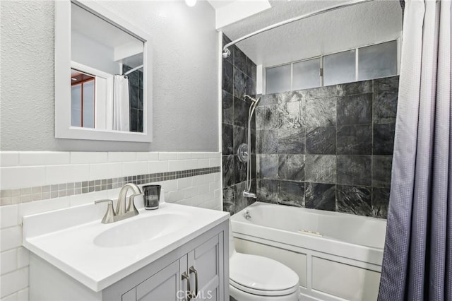 full bathroom with shower / bath combo, vanity, toilet, and tile walls