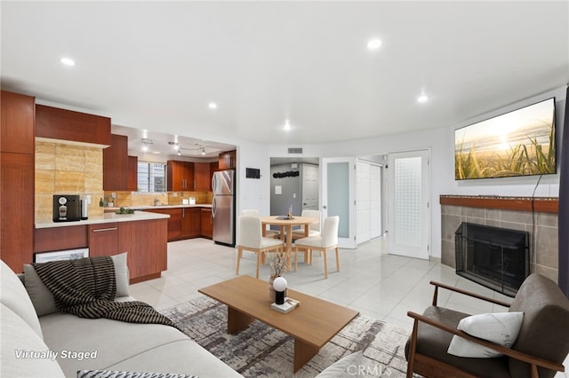 living room featuring light tile patterned floors and a tile fireplace