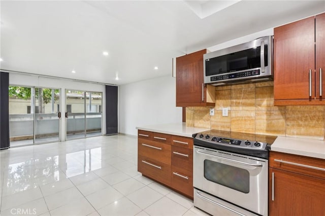 kitchen featuring decorative backsplash, light tile patterned floors, and stainless steel appliances