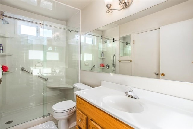 bathroom featuring vanity, toilet, and an enclosed shower