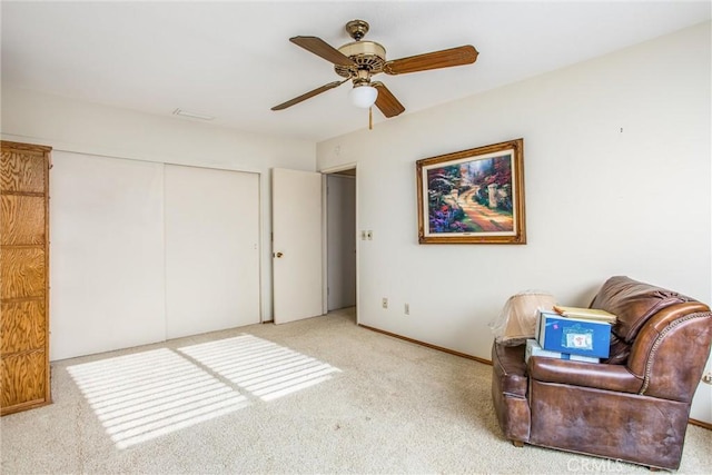 living area with ceiling fan and light colored carpet