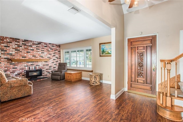 entrance foyer featuring a wood stove, ceiling fan, and dark hardwood / wood-style floors