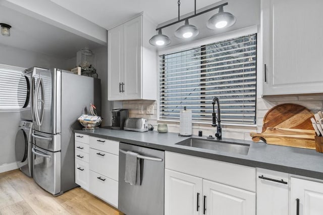 kitchen with white cabinetry, sink, plenty of natural light, decorative light fixtures, and appliances with stainless steel finishes