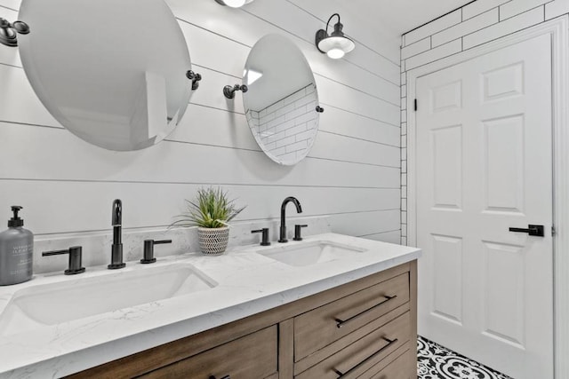 bathroom featuring vanity and wooden walls