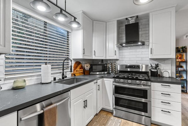 kitchen featuring sink, white cabinets, wall chimney range hood, and appliances with stainless steel finishes