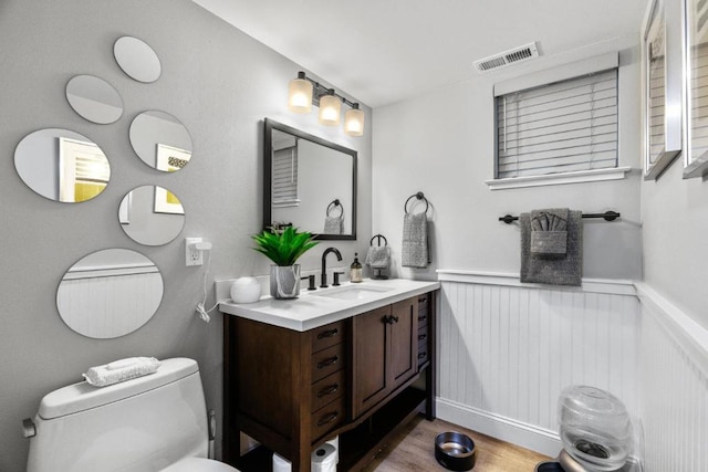 bathroom with vanity, toilet, and wood-type flooring