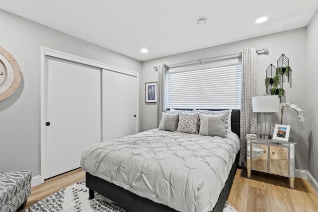 bedroom with light wood-type flooring and a closet