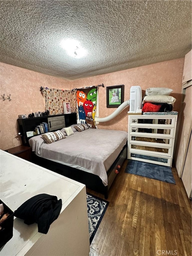 bedroom featuring a textured ceiling and hardwood / wood-style flooring