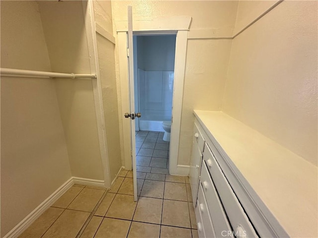 walk in closet with light tile patterned flooring