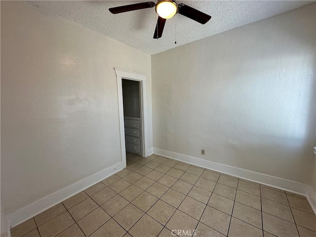 tiled empty room featuring a textured ceiling and ceiling fan