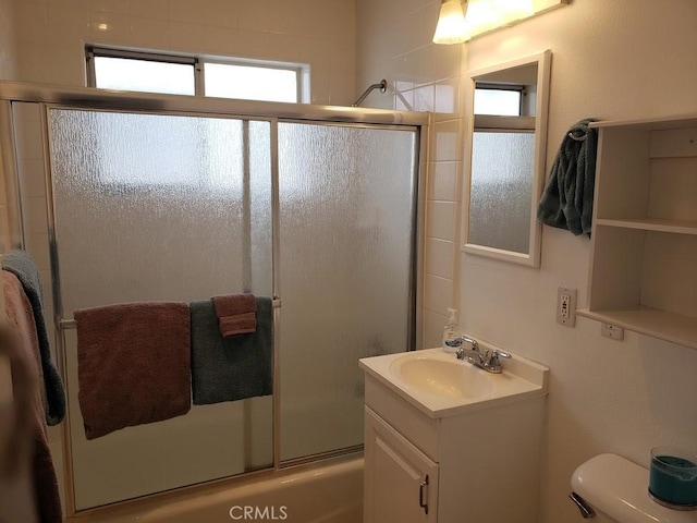 full bathroom with shower / bath combination with glass door, vanity, and toilet