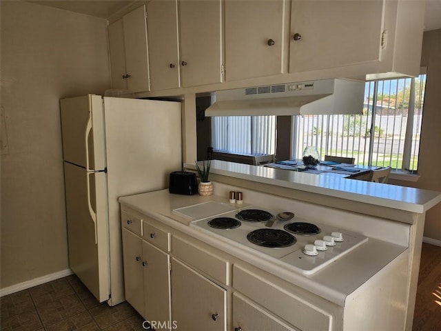 kitchen featuring white appliances, white cabinetry, and kitchen peninsula