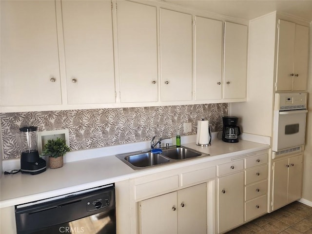 kitchen featuring dishwasher, decorative backsplash, white oven, and sink