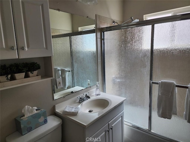 full bathroom featuring vanity, toilet, and enclosed tub / shower combo