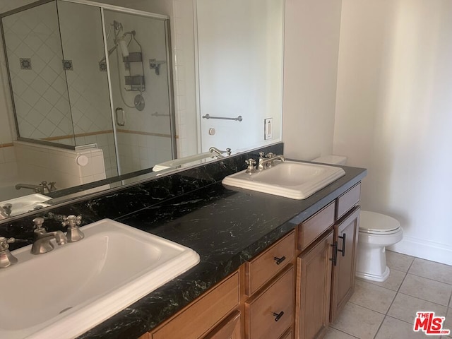 bathroom with tile patterned flooring, vanity, toilet, and walk in shower