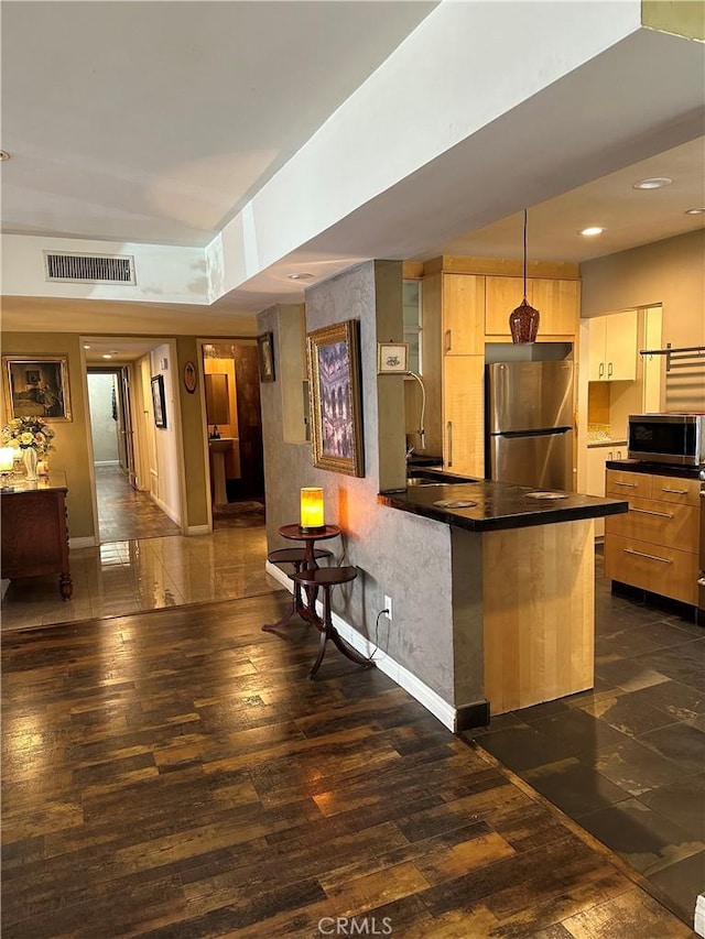 kitchen featuring sink, appliances with stainless steel finishes, hanging light fixtures, a kitchen breakfast bar, and kitchen peninsula