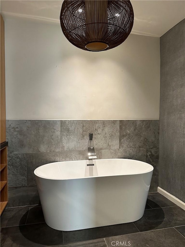 bathroom featuring a bath and tile walls