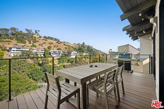 wooden terrace featuring a mountain view and a grill