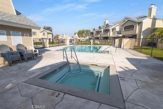 view of swimming pool with a patio area and a community hot tub