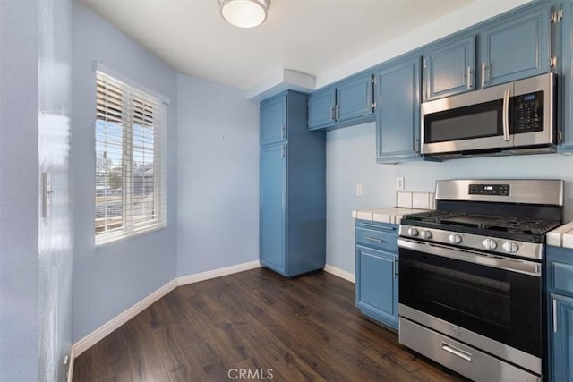 kitchen with dark wood-type flooring, stainless steel appliances, and blue cabinetry